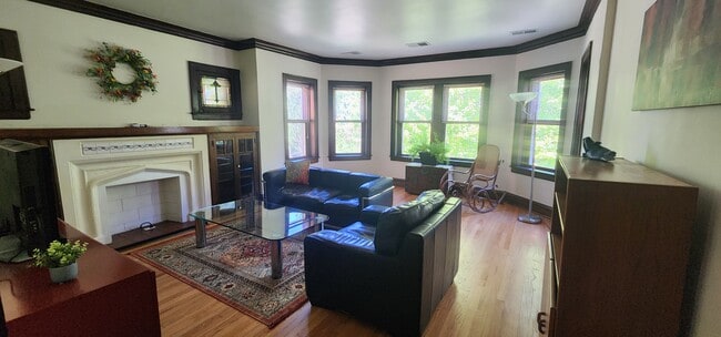 Living Room with leather sofa and armchair, antique rocking chair, large TV, floor lamps, & credenza - 2018 Lake St