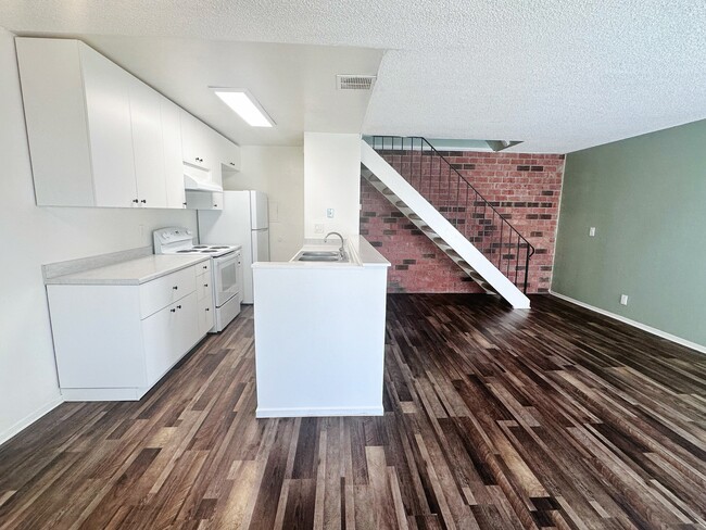 Viewing from dining area toward kitchen area and the stairs to beds and bath upstairs - 5494 Judith St Apartments Unit 3