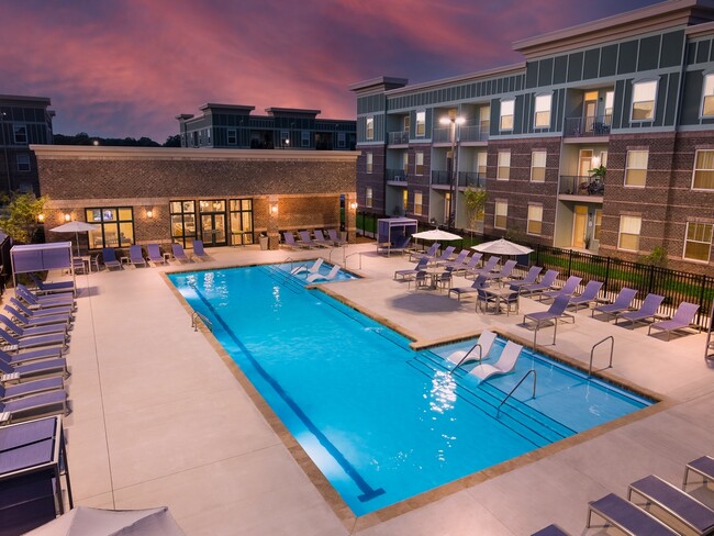 Resort-Style Swimming Pool with Sun Shelf and Fountains at Night - Ardmore at the Trail Apartments