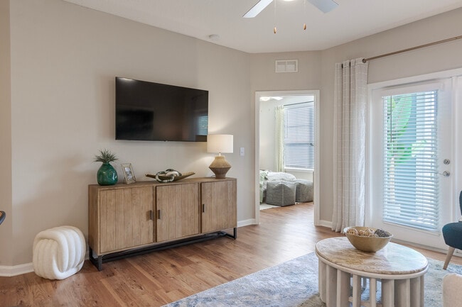 Newly Renovated Living Room with Sleek Hardwood Style Flooring - The Enclave at Tranquility Lake Apartments
