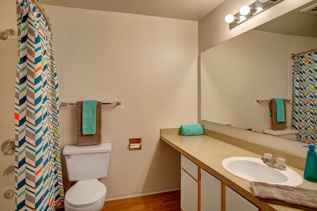 A large bathroom with a shower and tub, lots of cabinet storage, and a small vanity area - St. James Tower