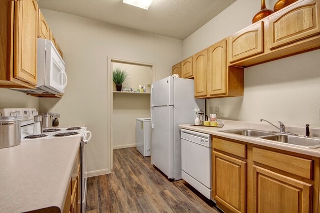 An open kitchen with lots of cabinet storage and easy access to the laundry room - The Residence at Heritage Park Apartments