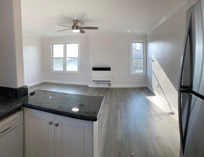 Spacious living room with ceiling fan, window A/C unit and heating unit - 358 22nd St Unit 4