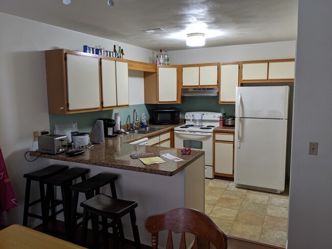 Kitchen with eat-in bar seating off of living room. - 892 Patrick Henry Dr