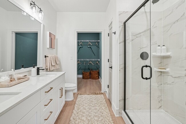 Bathroom with Quartz Countertops, Double Vanity Sinks, Walk-in Shower, and Walk-in Closet