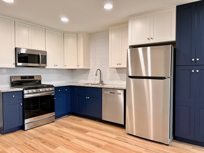 Kitchen with custom cabinets and all new appliances - 1266 Dove St Apartments Unit A