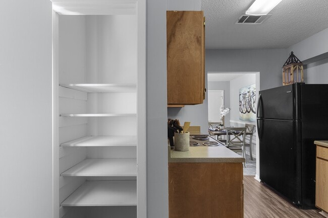houghtfully designed kitchens with black appliances and classic wooden cabinetry at Lakeland East Apartments in Flowood, MS. Managed by Highlands Vista Group.