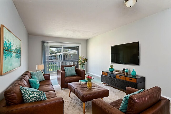 Inviting living room with elegant leather sofas, vibrant turquoise accents, and a sleek wall-mounted TV, perfect for relaxation and entertainment.