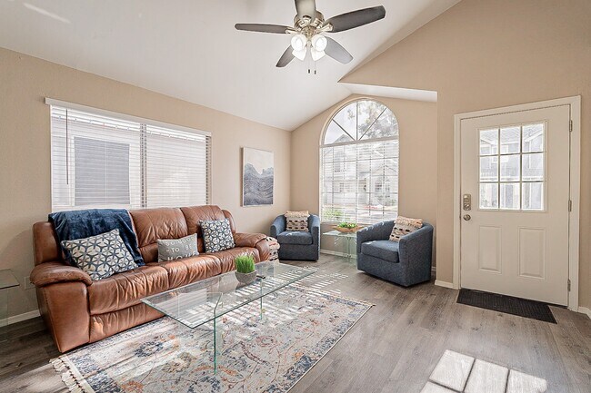 Living room with large 4k Smart TV on wall. Both sides of sofa recline and blue chairs pivot. - 235 N 22nd Pl House