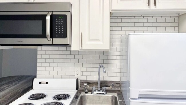 Discover chic and sleek living in our newly renovated apartments with a dazzling white subway tile backsplash, stylish white cabinetry, and granite-inspired countertops.