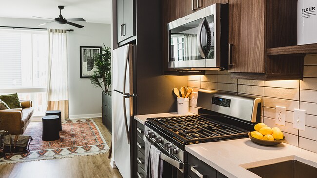 Chef-inspired galley kitchens with gas cooking, quartz counters and tile backsplash
