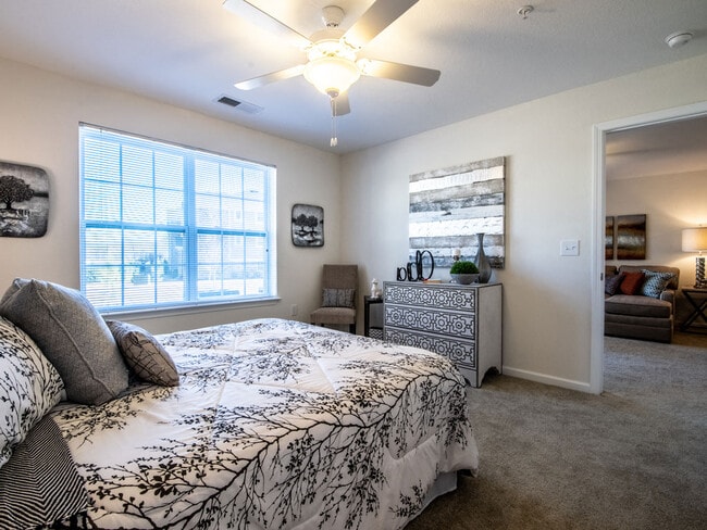 Carpeted Bedroom with Ceiling Fan - Killian Lakes Apartments and Townhomes