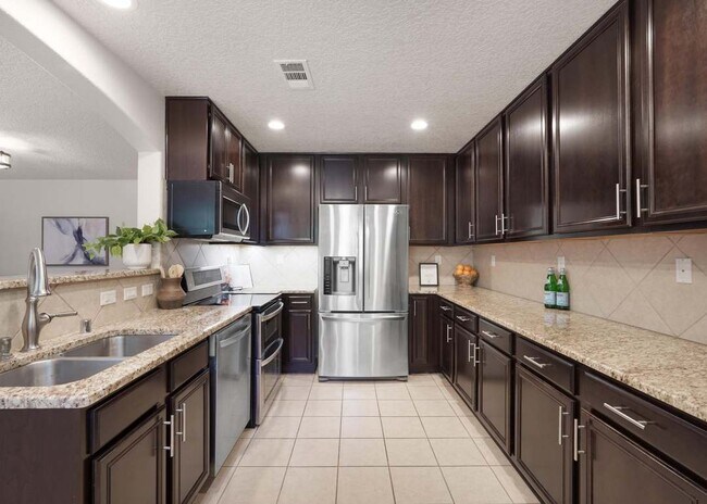 Kitchen w/ granite countertops and Stainless steel appliances