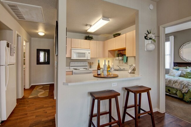 A kitchen with light cabinets and white appliances - Pala Mesa