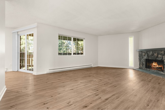 Experience warmth and style in this expansive living room, perfect for family gatherings. - Ridgedale Apartments