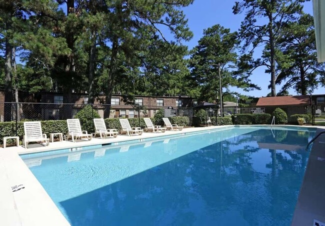 Unwind by the sparkling pool at Arbor Terrace, surrounded by lush landscaping and comfortable lounge chairs. This inviting outdoor space offers the perfect escape for relaxation and socializing. Schedule your tour today!