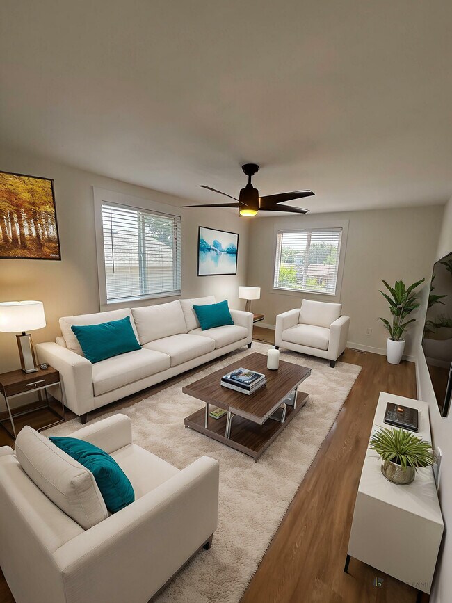 Elegante sala de estar con modernos sofás blancos, cojines verde azulado vibrantes y una elegante decoración de madera, perfecta para un ambiente hogareño acogedor. - 212-218 Longs Peak