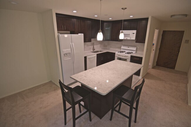 Open kitchen, with isle and pandant lights - 1250 Park Ave W Unit 408