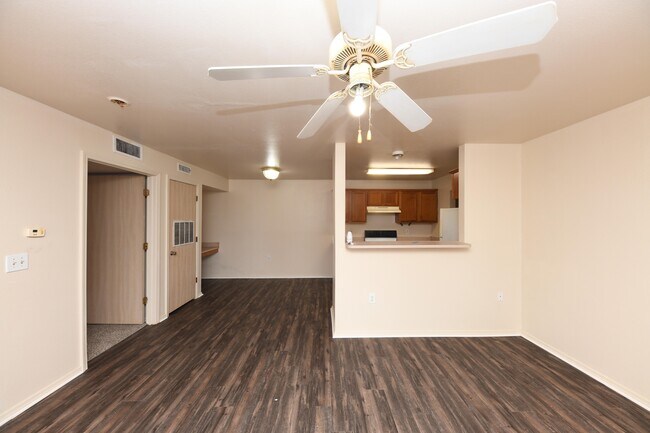 Spacious living room with hardwood-style flooring & ceiling fan
