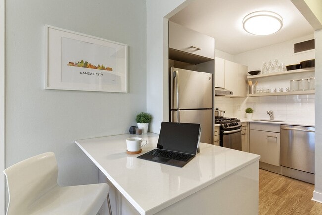 Open kitchen with stainless steel appliances and quartz countertops