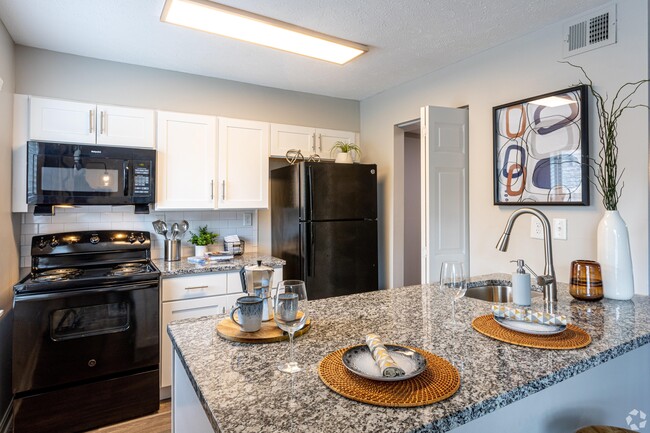 Kitchen with granite counters and black appliances