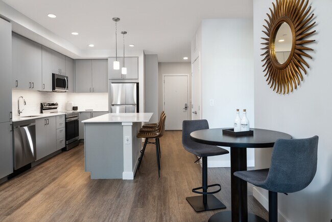 Kitchen, living, and dining areas with hard surface flooring throughout
