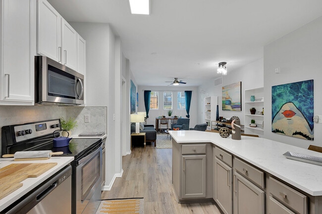 Modern open-plan kitchen and living area with sleek cabinetry, stainless steel appliances, and vibrant decor, offering a stylish and inviting ambiance.