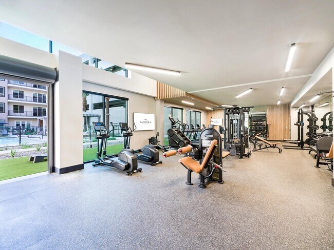 Floor-to-ceiling windows and open views of the pool bring natural light into this well-equipped fitness studio designed for all workout styles.