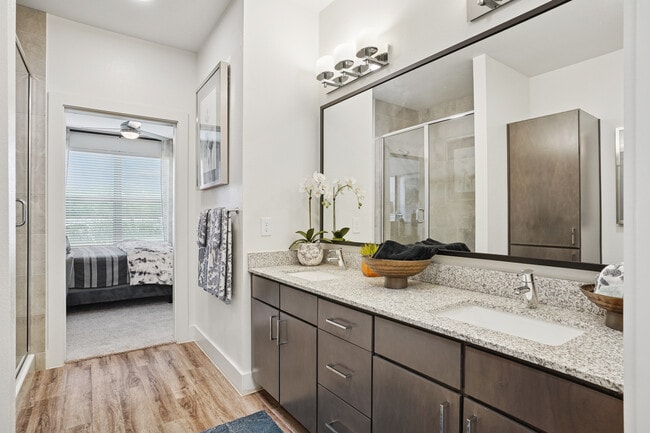 Bath with espresso cabinetry, speckled granite countertops, and hard surface flooring