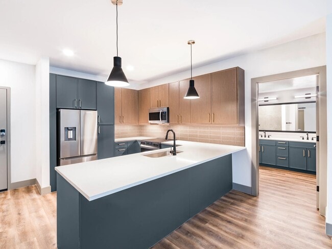 A clean, contemporary kitchen with bold cabinetry, generous counter space, and designer lighting.