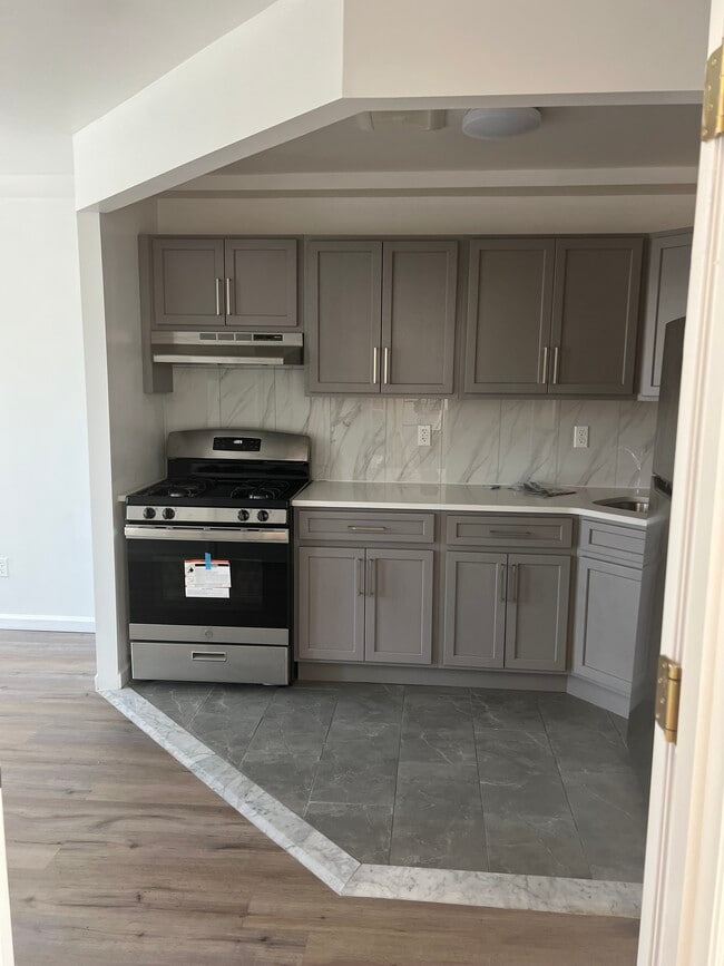 Open kitchen layout complete with countertops and rich wooden cabinetry - 1835 Atlantic Ave Apartments Unit 3