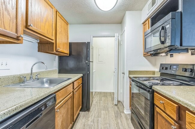 Well-appointed kitchens feature wood cabinetry and sleek black appliances for everyday convenience, professionally operated by Highlands Vista Group.