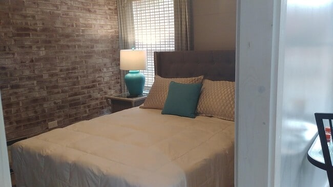 Bedroom with whitewashed brick, has fan - 58 Larose Dr SW