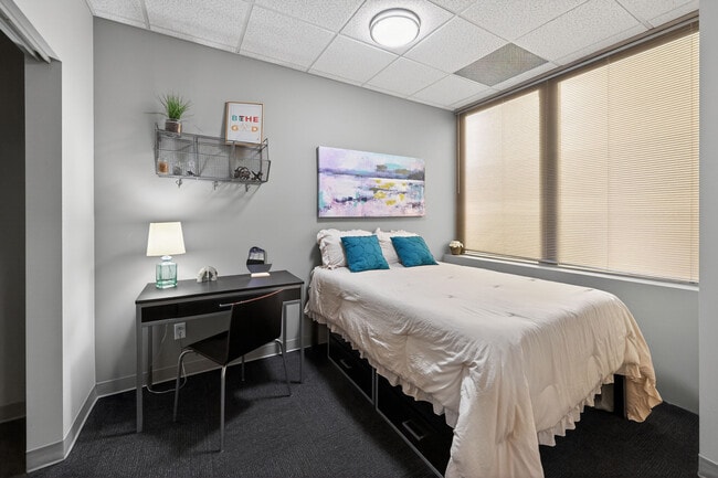 Furnished Bedroom with Dedicated Study Area and Under-Bed Storage at University Plaza NIU Apartments