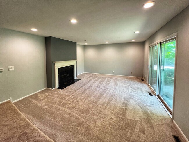 Open livingroom, new carpet, exit to patio - 1250 Park Ave W Unit 408