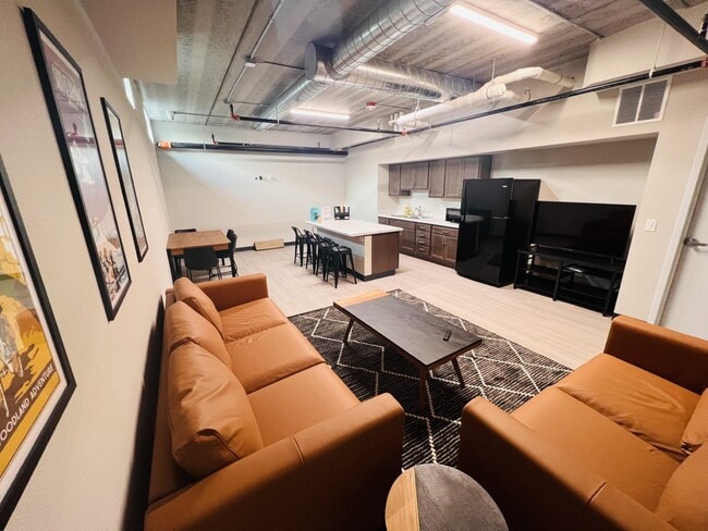 It has a kitchen, an island, comfy couches, and plenty of additional seating.