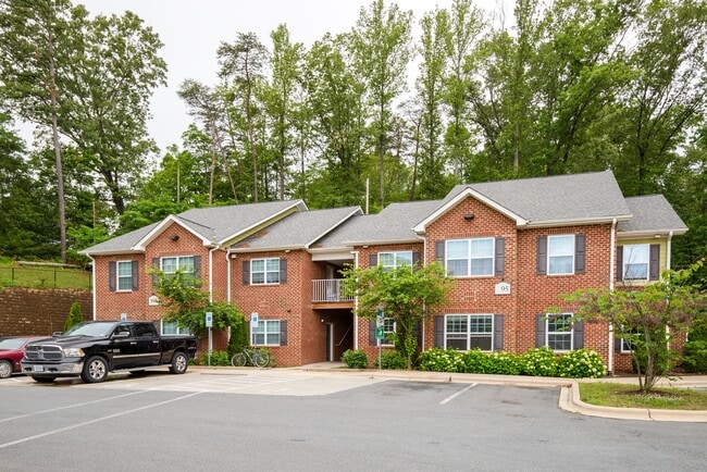 Charming red brick apartment homes surrounded by lush greenery—where peaceful living meets thoughtful design.