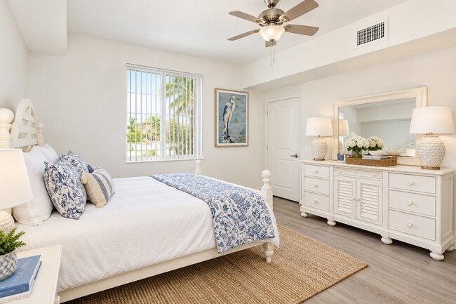 Unwind in the serene elegance of Quantum Lake Villas. This beautifully designed bedroom features natural light, a stylish ceiling fan, and chic furnishings that create a peaceful retreat. Enhance your lifestyle today—schedule a tour now!
