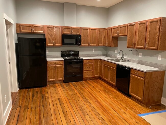 New kitchen cabinets, appliances and original refinished floors. Main room looking south. - 204 E Broadway Ave Unit B
