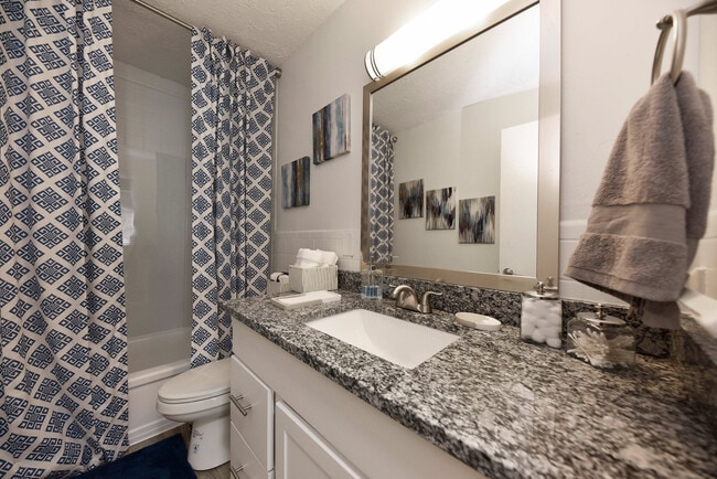 Bathroom with granite counters and bathtub