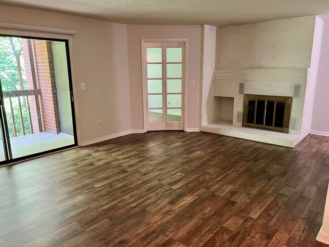 Living room with fireplace, private deck and home office behind French doors - 117 Turtle Creek Rd Unit Turtle Creek Condo