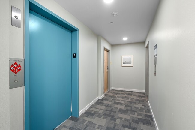 This modern hallway features a sleek design with a striking blue door, adding a pop of color to the space.