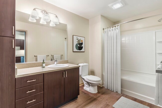 Renovated Package I bath with grey speckled granite countertop, espresso cabinetry, and hard surface flooring