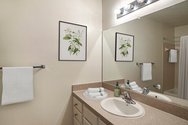 Renovated Package I bath with laminate countertops, white cabinetry, and hard surface flooring