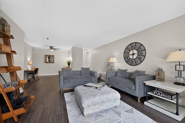 Settle into a stylish living room featuring a grey couch and a charming layout at Renaissance at Carol Stream in Carol Stream, IL.