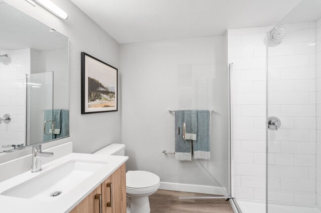 Finish Package II Bath with oak cabinetry, white quartz countertops, and hard-surface vinyl plank flooring