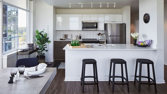 Apartment Kitchen with Stainless Steel Appliances, quartz counters and wood floors. - Griffis South Waterfront Apartments