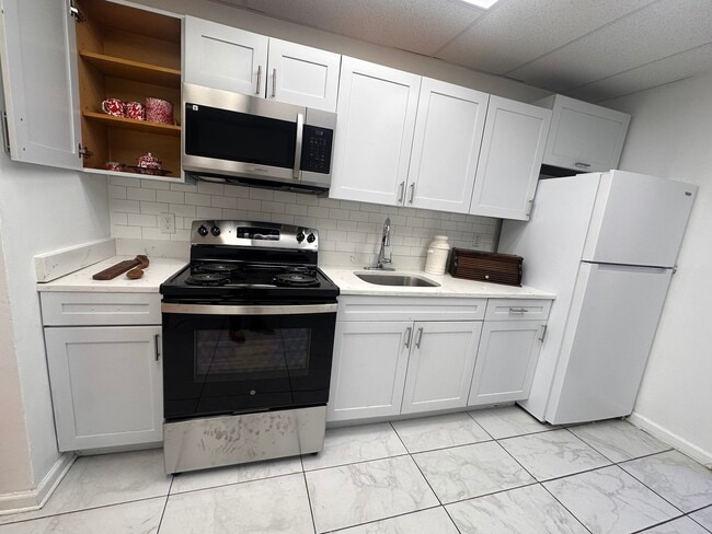 Fresh white kitchen with a brand-new stove and modern appliances. - 353 High St
