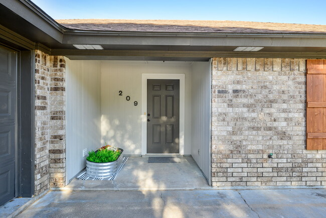 View of the freshly painted entrance to property. Room for small seating area or planters. - 209 Prairie Wind Blvd House