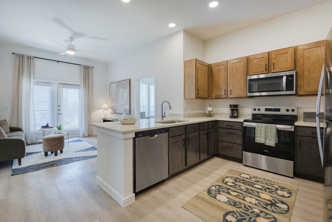 Open-concept kitchen with a peninsula overlooking the living area at Sageland Flats at Brooks - Sageland Flats at Brooks